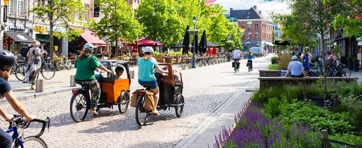 Fietsers en bakfietsen in een autovrije winkelstraat in het centrum van Mechelen.